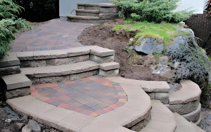 Hardscape construction crew building a stone patio